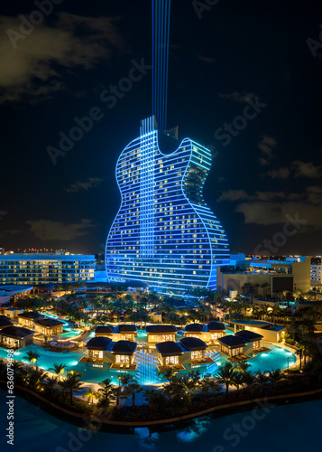 Aerial view of guitar shaped Seminole Hard Rock Hotel and Casino structure illuminated with bright neon colorful lights in Hollywood, Florida