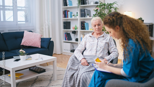 The doctor advises medication to an old female patient and writes a prescription