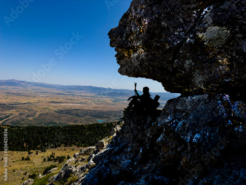 mountaineer resting in the shade in the summer heat and watching the magnificent view