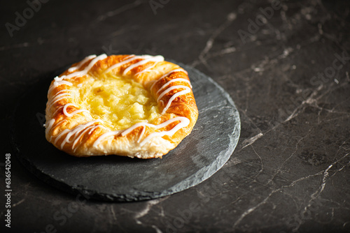 Mouth-watering apple and custard fruit danish topped with fondant and icing sugar.