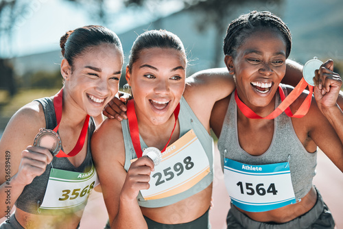 Happy women, award and celebration in olympic winning, running or competition together on stadium track. Group of athletic people smile in happiness, medal or victory in sports marathon or success