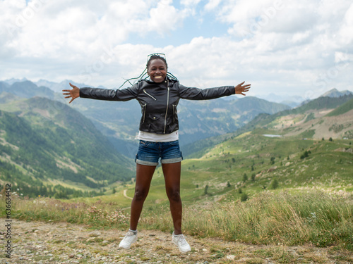 young woman jumping happy and enjoying nature in italian alps
