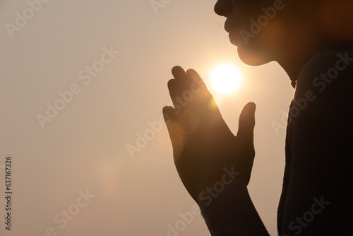 Silhouette of woman prayer position, Praying hands with faith in religion and belief in God on dark background. Power of hope or love and devotion. Namaste or Namaskar hands gesture.