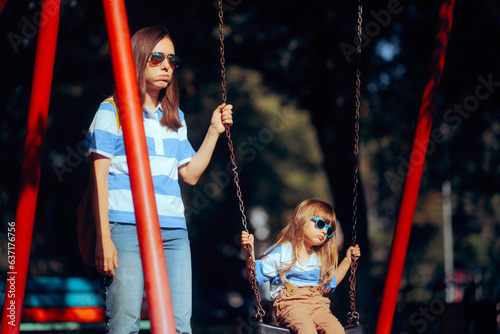 Tired Mom and Kid Feeling Bored at the Playground. Mother and daughter not speaking after an argument 