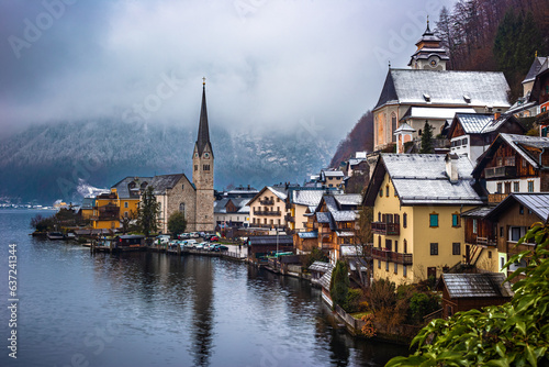 Hallstatt, Austria - Classic view of world famous Hallstatt, the Unesco protected lakeside town with Hallstatt Lutheran Church on a cold foggy day with snowy winter rooftops at Salzkammergut region