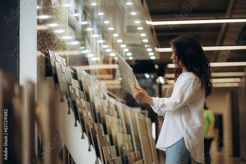 Female customer choosing kitchen ceramic tile in store