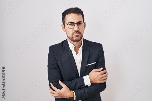 Handsome business hispanic man standing over white background shaking and freezing for winter cold with sad and shock expression on face