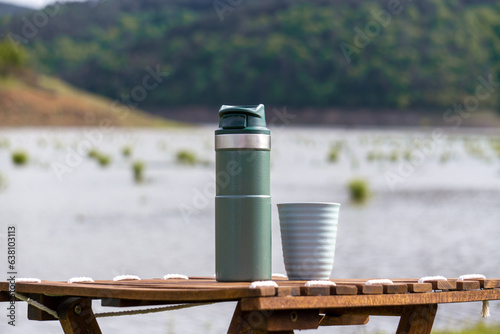 Isolated Stanley thermos without logo. Steel thermos for hot drinks at the camping table by the lake. 