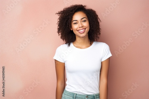 attractive smiling female with brown hair wearing white tshirt for mock up on plain pink background