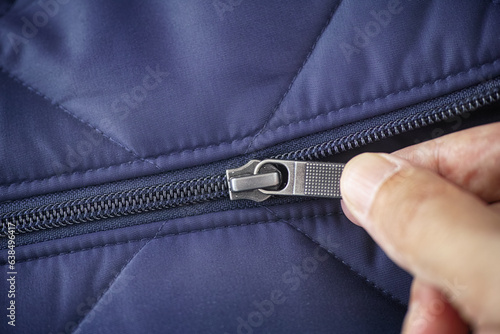 Closeup shot of a zipper on a blue jacket. Unzip a zip