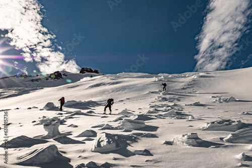 Skitourengänger auf einem alten Lawinenkegel im Aufstieg zum Risetenpass