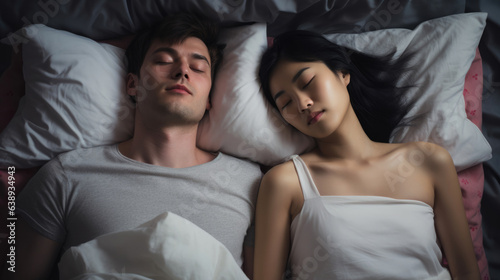 Snoring man. Couple in bed, men snoring and women can not sleep, covering ears with pillow for snore noise. Young interracial couple, Asian woman, Caucasian men sleeping in bed at home.