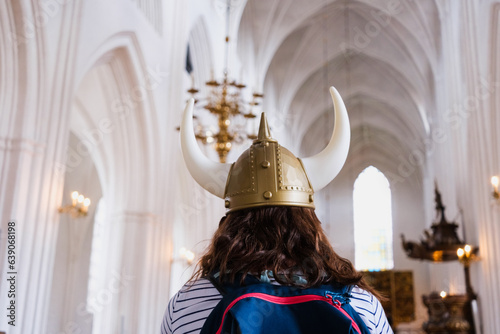 Tourist inside a church in a Viking costume, disrespectful of the space for religious gathering.