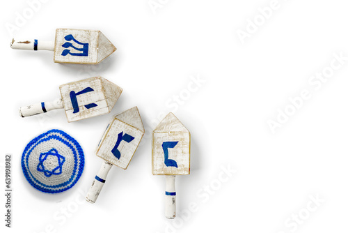 Kippah and Dreidel. Yarmulke with Star of David, dreidle or dreidl with blue lettering on white background. Four-sided spinning top, played during the Jewish holiday of Hanukkah, Jewish teetotum