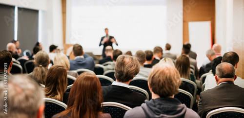 Speaker giving a talk in conference hall at business event. Rear view of unrecognizable people in audience at the conference hall. Business and entrepreneurship concept