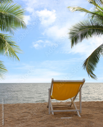 Beach chair on the white sand beach and coconut palm tree with cloudy blue sky