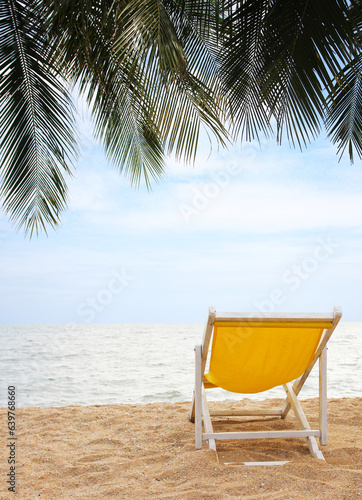 Beach chair on the white sand beach and coconut palm tree with cloudy blue sky