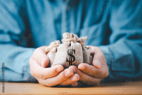 Businessman holding money bag with USD dollar sign for give dividend return profit from investment funding and stock market , Financial and accounting concept.