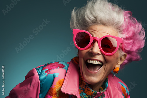 Happy, cool, fashionable old lady in outrageous pink clothes and sunglasses.