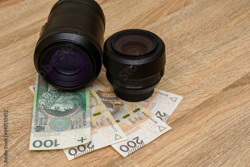 Obiektywy do aparatu fotograficznego obok polskich banknotów 