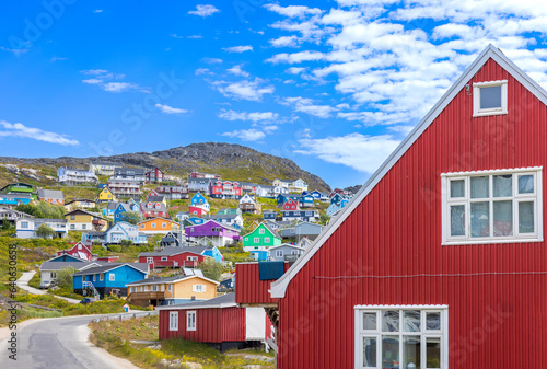 Typical architecture of Greenland city Qarqotoq with colored houses located near fjords and icebergs.