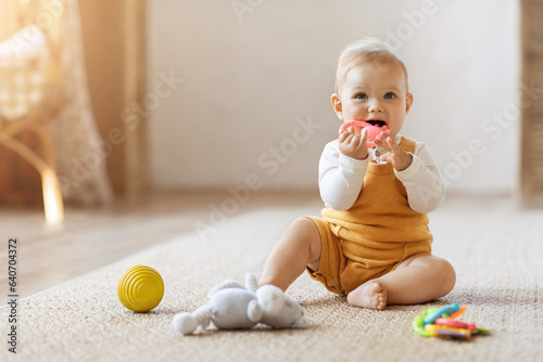 Cute blonde toddler baby playing with kids toys at home