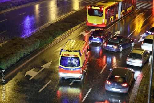 Karetka medyczna ratunkowa w deszczu na sygnale jedzie na sygnale jedzie wieczorem z pomocą