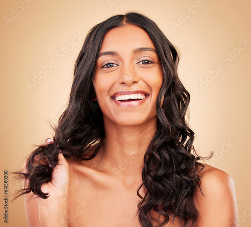 Hair care, smile and portrait of woman in studio with salon keratin treatment for curls. Makeup, cosmetic and headshot of Indian female model with long, shiny and clean hairstyle by brown background.
