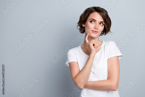 Photo of dreamy charming lady wear white t-shirt finger chin looking empty space isolated grey color background