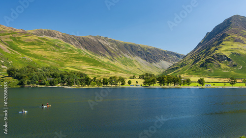 Kayaks and paddleboards on a calm, peaceful lake surrounded by tall mountains (Buttermere, Lake Distrtict)