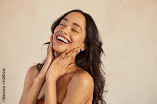 Beautiful laughing woman touching her skin with joy