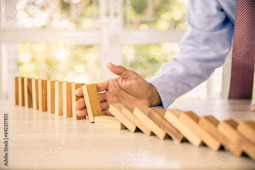 Close-up hand prevent wooden block not falling domino concepts of financial risk management and strategic planning and business challenge plan or safety insurance.