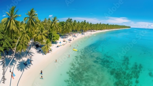 Beautiful summer tropical beach with white sand, palm trees, turquoise ocean water and tourists swimming in clear transparent turquoise water.