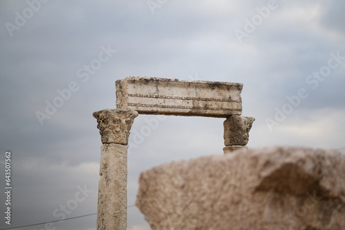 Monumental marble columns stand tall, although the surrounding structure has long since collapse. The freestanding ruins are deeply weathered, from a Roman building at the Amman Citadel in Jordan.