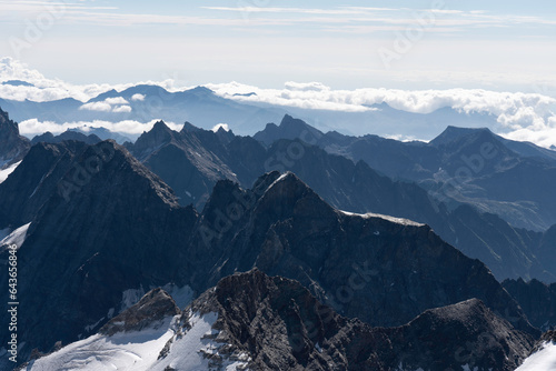 View from Gran Paradiso (National Park) mountain summit: glaciers of the massif and high rocky peaks. Mountains landscape.