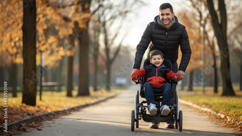Father drives his son in a wheelchair through a fall park