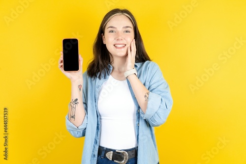 Beautiful woman wearing casual clothes hold hand modern technology use touch face palm astonished impressed scream wow omg unbelievable unexpected