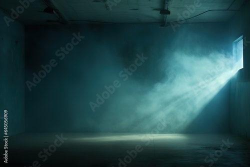 Big dark, empty prison cell with rays of light in the smoke and a spot of light on the floor.