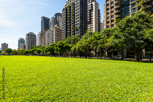 Low-angle view of green park space and modern buildings on both sides in downtown Taichung, Taiwan. here is near the National Taichung Theater.