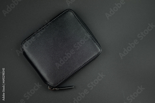 Black leather wallet with zip on a black background. Close up