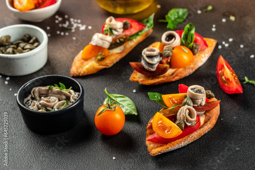 Delicious sandwiches with anchovies and tomatoes on a dark background, Food recipe background. Close up