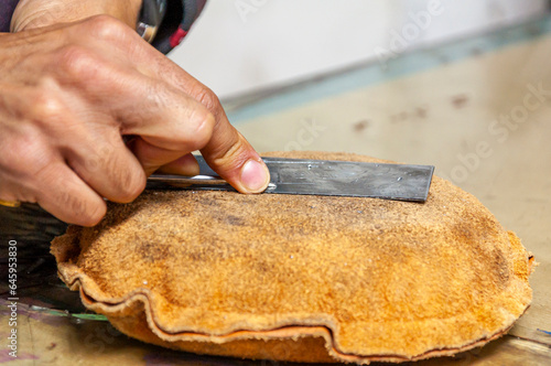 Particolare di mani che lavorano una lastra per incisione con tecnica di bulino