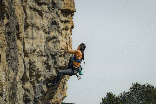 Intrepid Black-Haired Woman Rock Climbing Outdoors