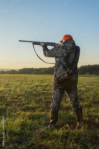 hunter hunting at autumn field at dawn.