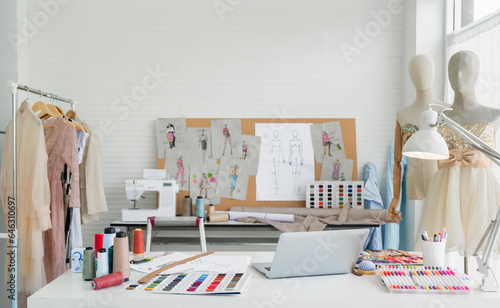 Workplace of designer dressmaker with clothes, dummy mannequin, and other equipment in the fashion studio.