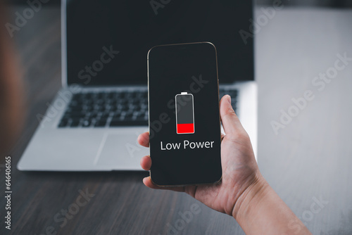 Close up man's hands using smart phone battery low charge battery screen, Businessman holding a smartphone Low battery warning on a mobile phone. Need to connect the charger to the smartphone icon