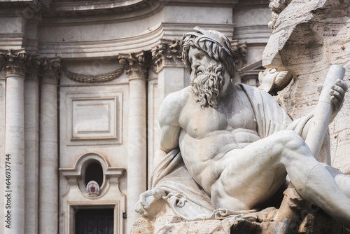 Close-up detail of biblical figure in Bernini's sculpted Baroque Fountain of the Four Rivers in Piazza Navona, a popular tourist landmark in the historic old town of Rome, Italy.