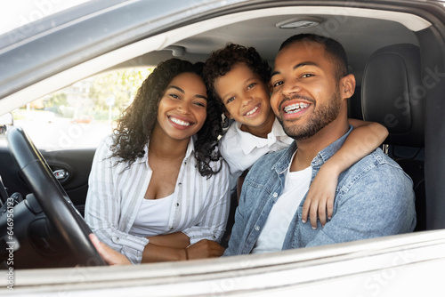 Happy african american family riding car traveling by automobile