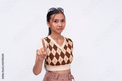 A slightly miffed asian woman giving a gentle warning and reminder. Isolated on a white background.