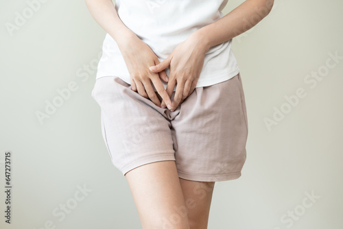 woman having painful lower stomach and hands holding pressing her crotch lower abdomen